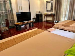 马尼拉MARIKINA 32 sqm Studio for Transients w WiFi 40 inch TV Parking的酒店客房设有两张床和一台平面电视。