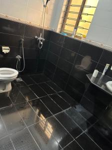 拉合尔Bahria Town - 10 Marla 2 Bed rooms Portion for families only的黑色瓷砖浴室设有卫生间和淋浴。