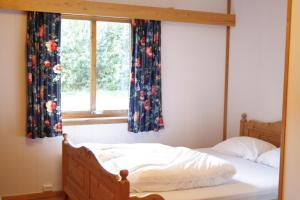 DovreskogenDovreskogen Gjestegård AS的卧室内的一张床位,卧室内拥有带窗帘的窗户
