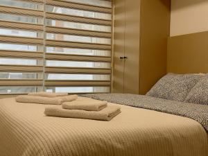 蒂瓦特Caruso apartment的一间卧室配有带毛巾的床