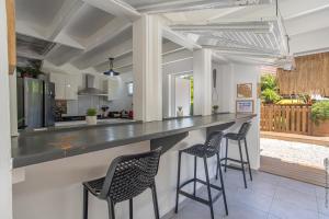 莱特鲁瓦西莱Villa Mahana的厨房以及带柜台和凳子的客厅。