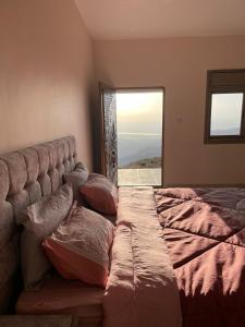Ad Dimnahمزرعة الشفق的卧室配有带枕头的床铺和窗户。