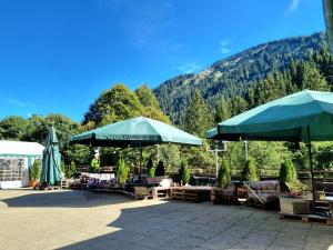 阿尔高内的伊门施塔特Berghotel Almagmach的一个带遮阳伞和桌椅的山景庭院