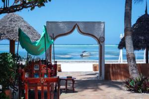 马特姆维Zanzibar House Boutique Hotel的海滩上的拱门,水中有船