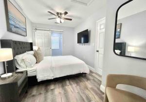 西棕榈滩Downtown West Palm Apartment Near Airport的卧室配有白色的床和镜子