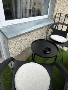 叶卡布皮尔斯Hugo 2的阳台配有两把椅子和一张桌子,阳台设有窗户