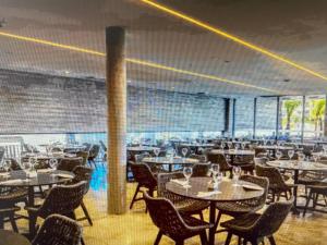 萨利诺波利斯Salinas Premium Resort Ap 1 QT的一间带桌椅的用餐室和大窗户