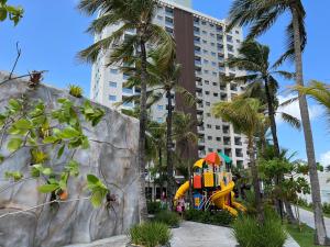 萨利诺波利斯Salinas Premium Resort Ap 1 QT的棕榈树建筑前的游乐场