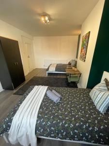 伦敦Willesden Green ROOMS的一间卧室配有两张床和一张桌子