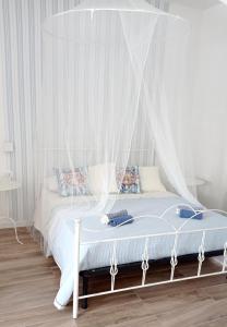 伊斯皮卡IL GUFO DELLA MARZA的卧室内的白色床和天蓬