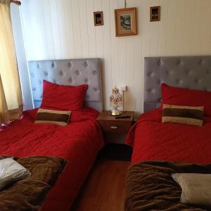 伊基克Casa dos dormitorios的一间卧室配有两张带红色床单和床头板的床。