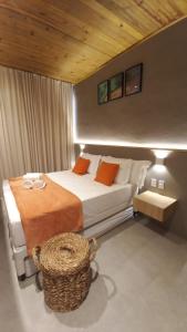 圣米格尔-杜斯米拉格里斯Cobertura Milagres do Chef的一间卧室配有一张带橙色枕头的大床