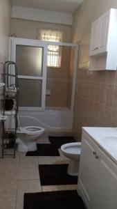 罗索The Seclusive Mansion的浴室配有卫生间、淋浴和盥洗盆。