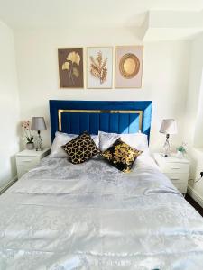 伦敦Luxury Morden 4 bedroom Flats which will make you unforgettable的一张带蓝色床头板和枕头的床