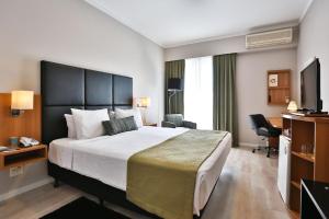 圣保罗Flat Privativo Comfort Ibirapuera的酒店客房设有一张大床和一台电视。