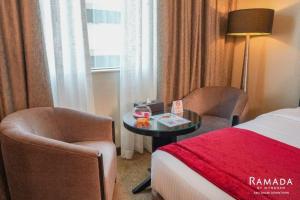 阿布扎比阿布扎比华美达市区酒店的酒店客房配有一张床、两把椅子和一张桌子