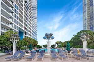 迈阿密Sun-Kissed & Sunshine! Direct Water and City Views的一组椅子和一个游泳池,位于大楼前
