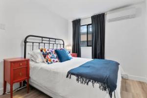 西基隆拿Mid-Century Modern Dream Retreat的一间卧室配有床、床头柜和窗户
