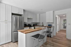 西基隆拿Mid-Century Modern Dream Retreat的厨房配有白色橱柜和木制台面