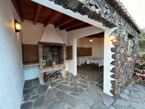 马佐Preciosa casa Canaria vista mar y montaña El encanto de Lita的房屋内带石头壁炉的庭院