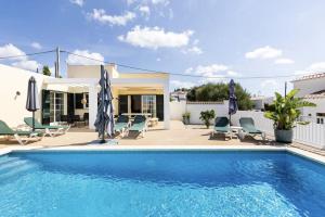 卡拉恩波特Villa Jordi - Cala en Porter的房屋旁的游泳池配有椅子和遮阳伞