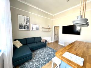 洛西茅斯Lossie Self-Catering Apartment的客厅配有蓝色的沙发和桌子