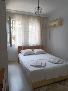 费特希耶2 Yatak Odalı Daire-Fethiye的一间卧室配有一张床,上面有两条毛巾