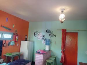 阿拉卡蒂MERMAID HOUSE, casa charmoso, wifi, parking, jardim, cozinha, central CANOA QUEBRADA的厨房设有橙色墙壁和冰箱