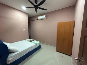 丹那美拉Homestay Taman Hidayah Chawas的一间卧室配有一张床和吊扇