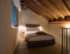 英杜诺欧罗纳Locanda Cà dei Santi的一间带一张床的卧室,位于带木制天花板的房间内