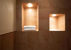 英杜诺欧罗纳Locanda Cà dei Santi的浴室设有两面镜子和一堆毛巾
