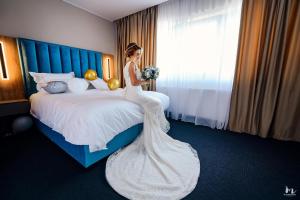 DrăgăşaniRiver Park Hotel的坐在床上的身着婚纱的女人