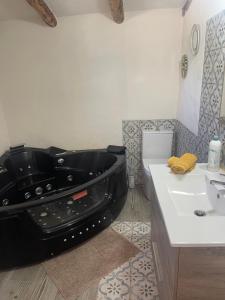 Los Santos de MaimonaFinca el Atardecer-Luna的浴室设有位于水槽旁的黑色浴缸。
