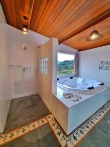 圣安东尼奥-杜皮尼亚尔南洋杉谷旅馆的带浴缸和窗户的大浴室