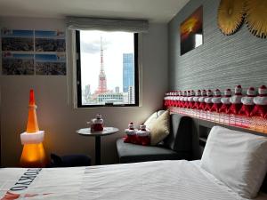 东京Henn na Hotel Tokyo Hamamatsucho的酒店的客房 - 带一张床、椅子和窗户