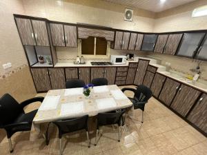 塔伊夫شقةكبيره 4 غرف منها 3 غرف نوم اطلاه مجلس صالة 4-room apartment, including 3 bedrooms, a living room, a sitting room, and a view的一间带桌椅的用餐室和一间厨房