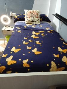 塞维利亚Ikigai House的一张带蓝色棉被的床,上面有叶子