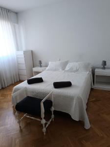 马德里Casa de Mirtha的卧室配有白色的床和两个枕头