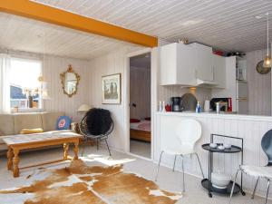 森讷比6 person holiday home in Juelsminde的厨房以及带桌椅的起居室。