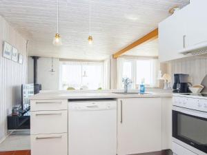 森讷比6 person holiday home in Juelsminde的厨房配有白色橱柜和水槽