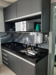 戈亚尼亚Luxo e conforto的厨房配有水槽和微波炉