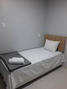 戈亚尼亚Luxo e conforto的白色墙壁间的一张床位