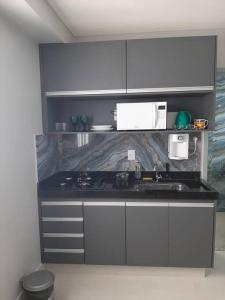 戈亚尼亚Luxo e conforto的厨房配有白色橱柜和黑色台面