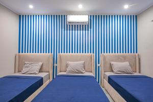赫尔格达Bedcoin Hostel的蓝色和白色条纹间内的两张床
