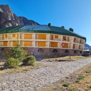 洛斯佩妮滕特斯Aires de Montaña - Departamento en Los Penitentes, Mendoza的山前有绿色屋顶的大建筑