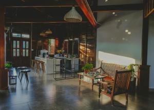 大叻Elon Coffee Farmstay的一间带桌椅的客厅和一间厨房