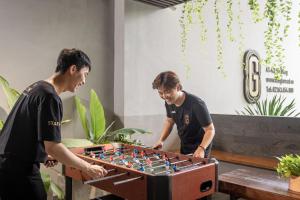 岘港The Glomad Danang Hotel的两个玩国际象棋的人