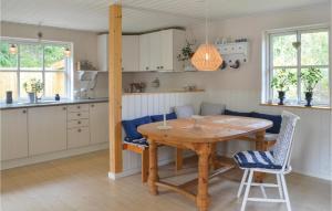 埃贝尔托夫特Cozy Home In Ebeltoft With Wifi的厨房以及带木桌和椅子的用餐室。