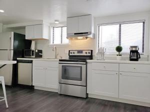 博伊西New on Bsu Campus 3 beds Fully Remodeled的厨房配有白色橱柜和炉灶烤箱。