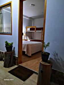 卡哈马卡Wayra Hospedaje的一间卧室配有一张床和两盆植物